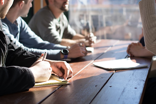 multiple people at a desk in a meeting